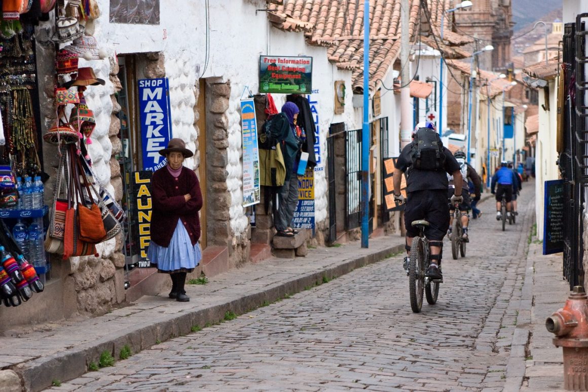 The crew rides down a steep narrow brick street in the tourist town of Cusco. Paul Morrison photo.