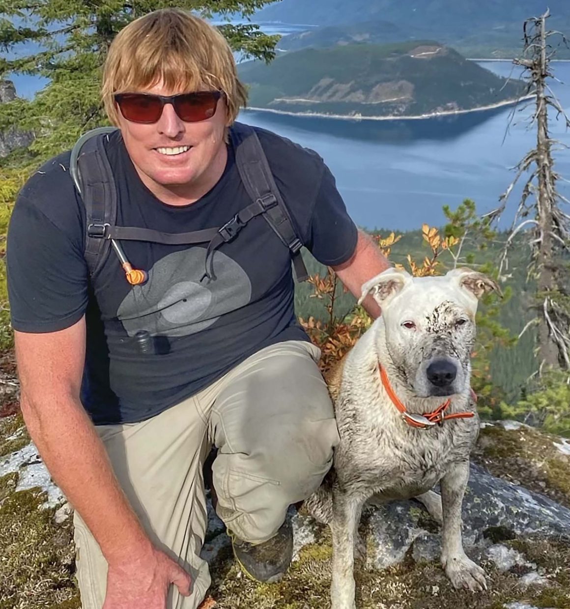 Gringa the dog, sitting with owner Lammers in the mountains.