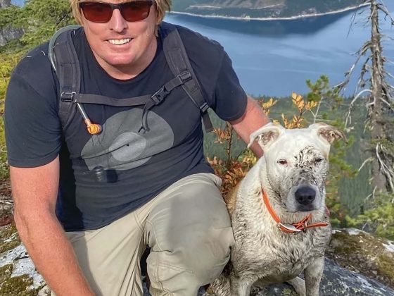 Gringa the dog, sitting with owner Lammers in the mountains.