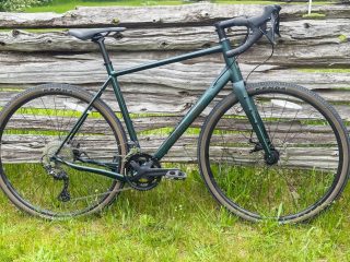 Opus Horizon gravel bike against a fence.