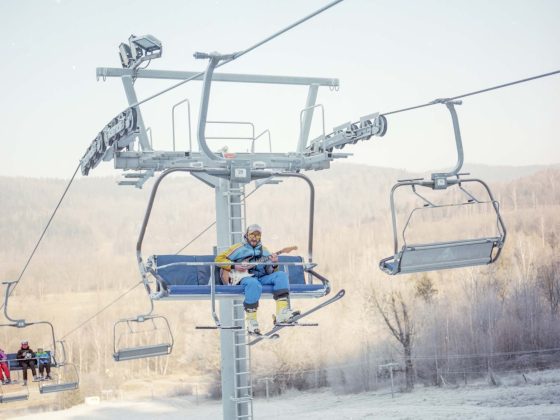 skier on chairlift playing guitar in Poland