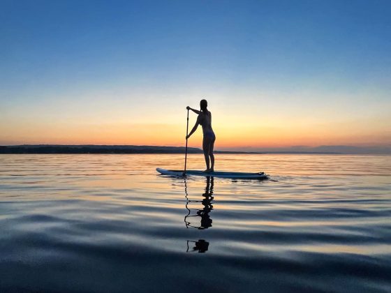 woman paddle boarding on Georgian Bay at sunset