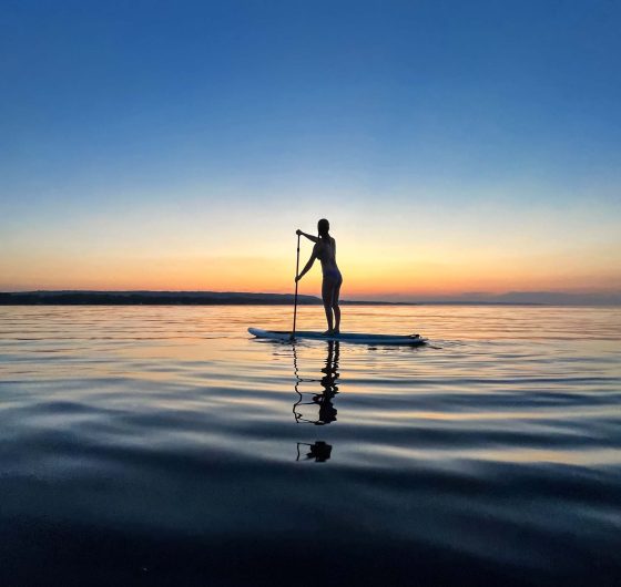 woman paddle boarding on Georgian Bay at sunset